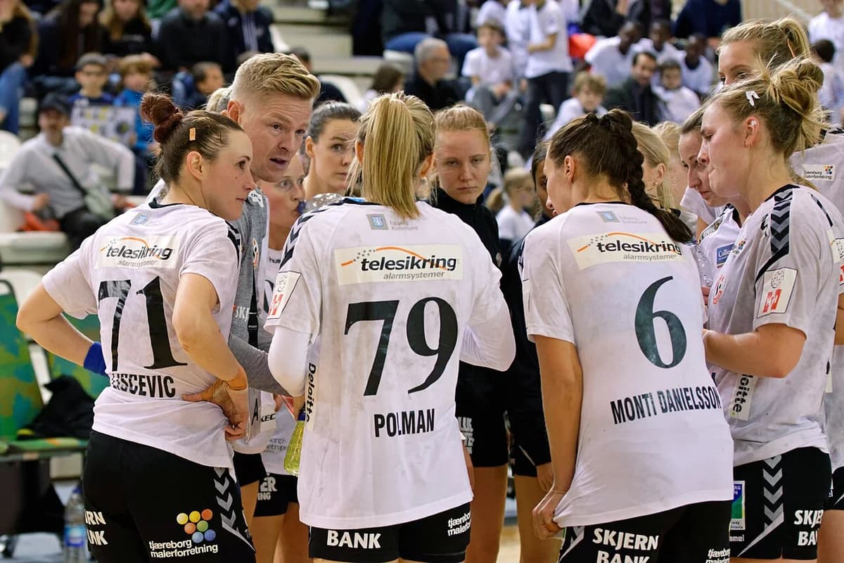 Women’s handball team huddling during a match.